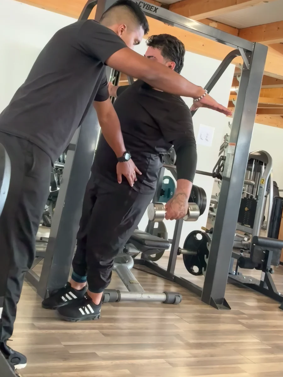 Rafael guide un pratiquant pendant un exercice de renforcement en salle.